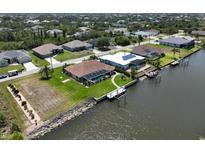 Waterfront homes feature private docks, screened pools, and manicured lawns in this aerial view at 9158 Melody Cir, Port Charlotte, FL 33981