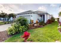 Beautifully landscaped front yard with colorful plants and well-maintained lawn at 9853 Bright Water Dr, Englewood, FL 34223