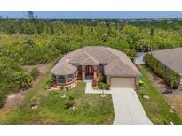 Expansive single-story home featuring a spacious lawn and a mature tree buffer for exceptional privacy at 10495 Atenia St, Port Charlotte, FL 33981