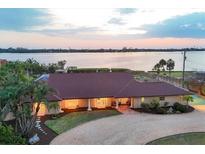 Waterfront home featuring a beautiful backyard, well manicured landscaping and a circular driveway at 1275 Bayshore Dr, Englewood, FL 34223