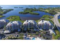 Stunning aerial view of waterfront condos, showcasing lush landscaping, bay views, and a resort-style pool at 13113 Gasparilla Rd # A503, Placida, FL 33946