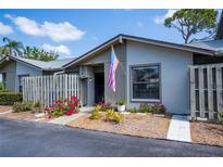 Charming home featuring a cozy entrance with an American flag and colorful landscaping at 148 Jose Gaspar Dr # 148, Englewood, FL 34223
