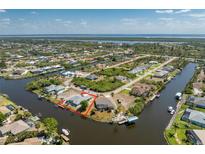 Aerial view of waterfront property with boat access and lush landscaping in a serene, coastal community setting at 15674 Applewhite Cir, Port Charlotte, FL 33981