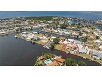 Waterfront home aerial view showcases a private pool and dock with easy access to the open water and scenic surroundings at 158 Morgan Se Ln, Port Charlotte, FL 33952
