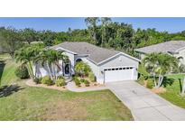 Charming home with lush landscaping, palm trees, and a well-manicured lawn showcasing curb appeal at 4004 Landor Ct, Venice, FL 34293