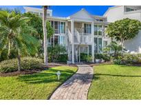 Charming two-story condo with lush landscaping and a welcoming brick path to the entrance at 5000 Gasparilla Rd # 23A, Boca Grande, FL 33921