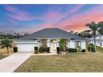 Inviting single-story home featuring lush landscaping, a two-car garage, and a well-manicured lawn at 642 Boundary Blvd, Rotonda West, FL 33947