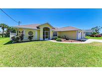 Charming single-story home featuring a well-manicured lawn and a screened entryway at 68 Long Meadow Ln, Rotonda West, FL 33947