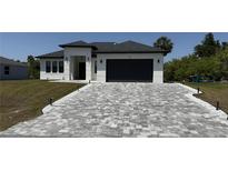 Charming single-story home featuring a paved driveway, two-car garage, and well-maintained landscaping at 725 Clearview Dr, Port Charlotte, FL 33953