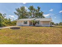 Charming single-story home with a well-manicured lawn and mature trees providing shade at 9149 Castlehill Ave, Englewood, FL 34224