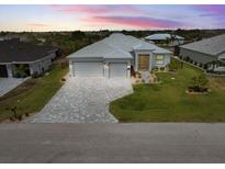 Beautiful single Gathering home featuring a three car garage, paver driveway, and well-manicured lawn at 10115 Long Branch St, Port Charlotte, FL 33981