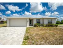 Charming single-story home featuring a two-car garage, manicured landscaping, and a light-colored exterior at 10164 Stonecrop Ave, Englewood, FL 34224