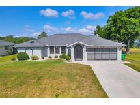 Charming single-story home with a well-manicured lawn and attached garage at 1035 Riggs St, Port Charlotte, FL 33952