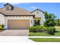 Charming single-story home featuring a tile roof, two-car garage, and a beautifully landscaped front yard at 11125 Mcdermott Ct, Englewood, FL 34223