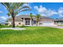 Charming single-story home with lush lawn, palm trees, and a well-manicured landscape at 119 Fairway Rd, Rotonda West, FL 33947