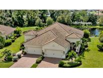 Beautiful exterior showcasing a tile roof, three-car garage, and lush landscaping at 1339 Backspin Dr, Englewood, FL 34223