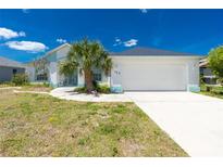Charming one-story home featuring a white exterior with a well-manicured lawn and a two-car garage at 162 Fairway Rd, Rotonda West, FL 33947