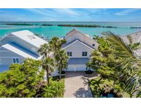 Beautiful waterfront home with lush landscaping and stunning views of the ocean and nearby islands at 16716 Grande Quay Dr, Boca Grande, FL 33921