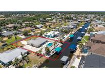 Expansive aerial view showcases a waterfront property with a private pool and boat dock on a scenic canal at 2673 Titania Rd, Englewood, FL 34224