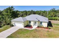 Charming single-story home with a well-maintained lawn, attached garage, and decorative landscaping at 2957 Montgomery Dr, Port Charlotte, FL 33981