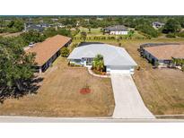 Lovely single-story home featuring mature landscaping, a two-car garage, and a long driveway at 311 Boundary Blvd, Rotonda West, FL 33947