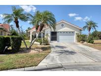 Charming single-story home with a two-car garage, tile roof, and beautiful landscaping including palm trees at 8320 Creekview Ln, Englewood, FL 34224