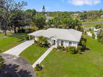 Expansive single-story home with a manicured lawn, a circular driveway, and lush landscaping at 1 Curacao Cir # 44, Englewood, FL 34223