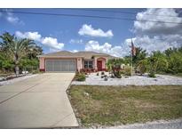 Charming single-Gathering home with a well-maintained front yard and American flag at 10064 Cocoa Beach St, Port Charlotte, FL 33981