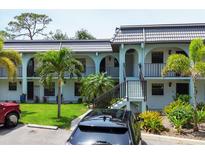 Inviting condo exterior featuring a courtyard, palm trees, and convenient parking at 149 Englewood Isles Pkwy # 603, Englewood, FL 34223
