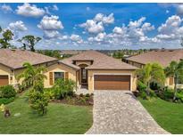 Charming single-story home featuring a well-manicured lawn, paver driveway and a two-car garage at 1836 W Isles Rd, Port Charlotte, FL 33953