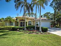 Charming single-story home with lush landscaping, palm trees, and a well-manicured lawn at 237 Rotonda E Blvd, Rotonda West, FL 33947
