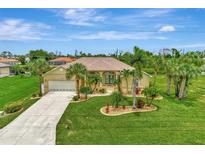 Stunning single-Gathering home with a well-manicured lawn and lush landscaping, including mature palm trees at 29 Tournament Rd, Rotonda West, FL 33947