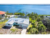 An exterior elevation shows a waterfront home with an aluminum roof, screened lanai, and dock access to the water at 4093 Pelican Shores Cir, Englewood, FL 34223
