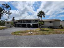 Two story condo with covered parking, palm tree, and well maintained lawn at 4260 Placida Rd # 21C, Englewood, FL 34224