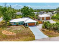 Charming single-Gathering home with a well-manicured lawn and a long driveway leading to an attached garage at 5250 Callaway St, Port Charlotte, FL 33981