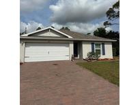 Charming single-story home with a brick driveway and a two-car garage at 5473 Hoffman St, Port Charlotte, FL 33981