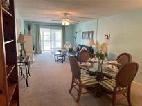Inviting living room with lots of light, a ceiling fan and an adjacent dining area at 708 Tamiami S Trl # 216, Venice, FL 34285