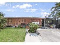 Charming single-story home with lattice accents, a well-kept lawn, and lovely landscaping at 857 Palmetto St, Englewood, FL 34223