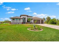 Beautiful single Gathering home with a three car garage, well manicured lawn, and upgraded paver driveway at 9470 Wacker Ter, Port Charlotte, FL 33981