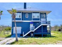 Stunning two-story coastal home featuring a durable metal roof, charming blue siding, and elevated decks at 9594 Doubloon Trl, Placida, FL 33946