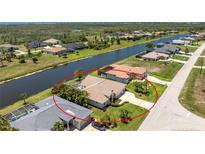 Waterfront home with lush landscaping, spacious driveway, and a serene canal view at 1157 Rotonda Cir, Rotonda West, FL 33947