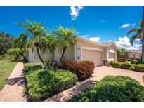 Beautiful single-story home featuring a two car garage, complemented by lush landscaping and well-maintained plants at 13392 Abercrombie Dr, Englewood, FL 34223