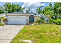 Charming single-story home with a well-manicured lawn and inviting double-door entry at 143 Crevalle Rd, Rotonda West, FL 33947