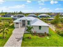 Beautiful single-story home featuring lush landscaping, a long driveway, and a well-manicured lawn at 15850 Viscount Cir, Port Charlotte, FL 33981