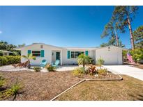 Inviting home features a well-manicured front yard with vibrant landscaping and a freshly painted exterior at 1691 Lakeview Pl, Englewood, FL 34223