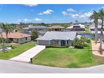 Charming single-Gathering home with lush lawn, mature landscaping, and a two-car garage in a waterfront community at 3025 Curry Ter, Port Charlotte, FL 33981