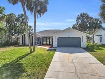 Charming single-story home with a well-manicured lawn and mature palm trees in a serene neighborhood at 4210 Day St, Port Charlotte, FL 33948