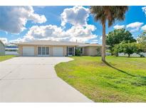 Well-maintained ranch-style home with three-car garage and mature landscaping on a sunny lot at 6206 Marcum St, Englewood, FL 34224