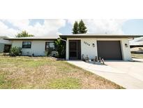Charming single Gathering home with front yard, walkway, and attached garage at 7234 Mamouth St, Englewood, FL 34224