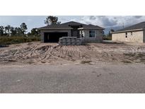 Unfinished home exterior, showcasing the initial construction phase, with the landscape yet to be finalized in the front yard at 12 Current Ln, Placida, FL 33946